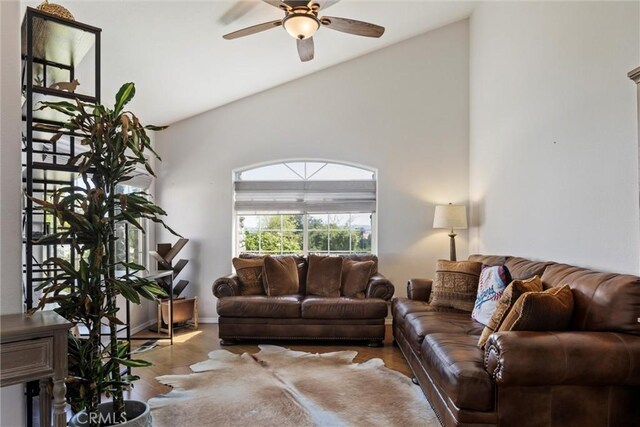 living room featuring ceiling fan, light wood-type flooring, and vaulted ceiling