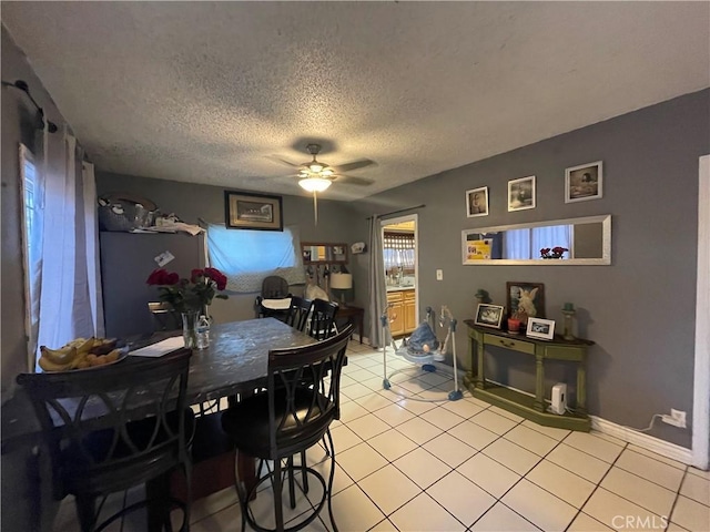 dining area with light tile patterned floors, a textured ceiling, and ceiling fan