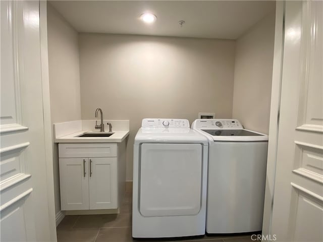 clothes washing area with dark tile patterned flooring, independent washer and dryer, and sink