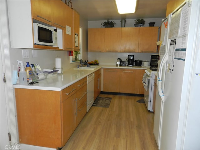 kitchen featuring light wood-type flooring, white appliances, and sink