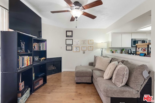 living room with ceiling fan and light hardwood / wood-style flooring