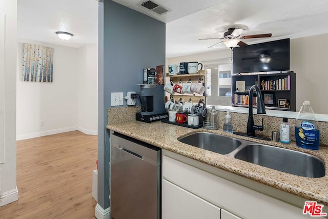 kitchen with ceiling fan, light stone counters, sink, light hardwood / wood-style flooring, and dishwasher