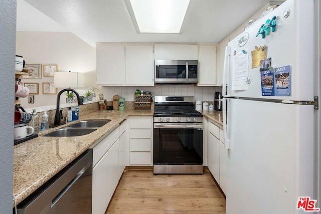 kitchen featuring sink, white cabinets, light hardwood / wood-style flooring, appliances with stainless steel finishes, and light stone countertops