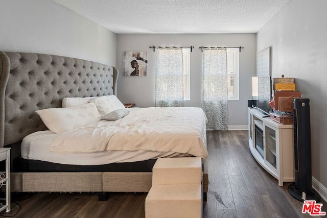 bedroom with a textured ceiling and dark wood-type flooring