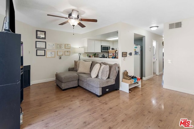 living room with ceiling fan and light hardwood / wood-style flooring