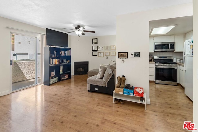 living room featuring light hardwood / wood-style floors and ceiling fan