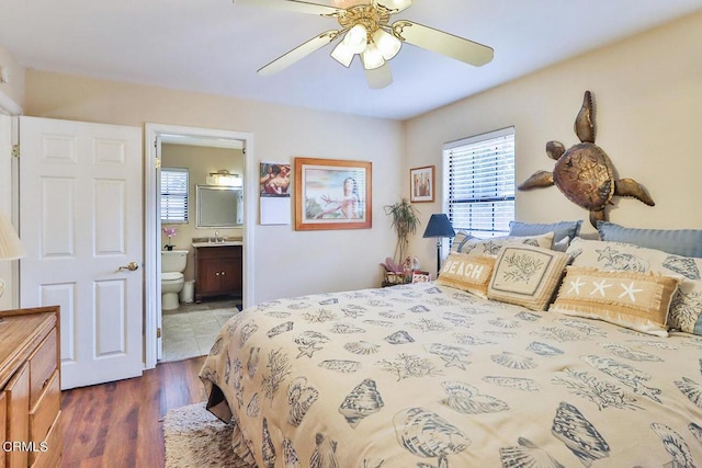 bedroom with dark hardwood / wood-style flooring, ensuite bath, ceiling fan, and sink