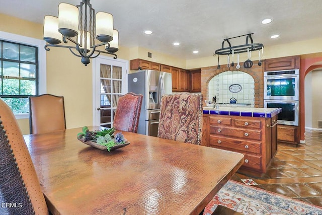 tiled dining space featuring a notable chandelier