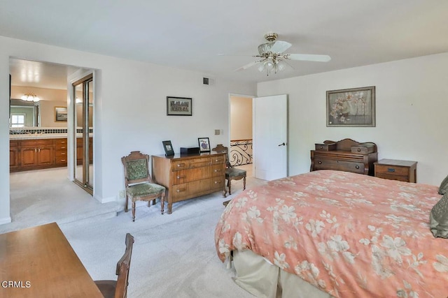 carpeted bedroom with ensuite bath and ceiling fan