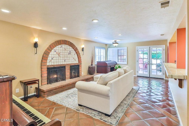 tiled living room featuring plenty of natural light, french doors, and a brick fireplace