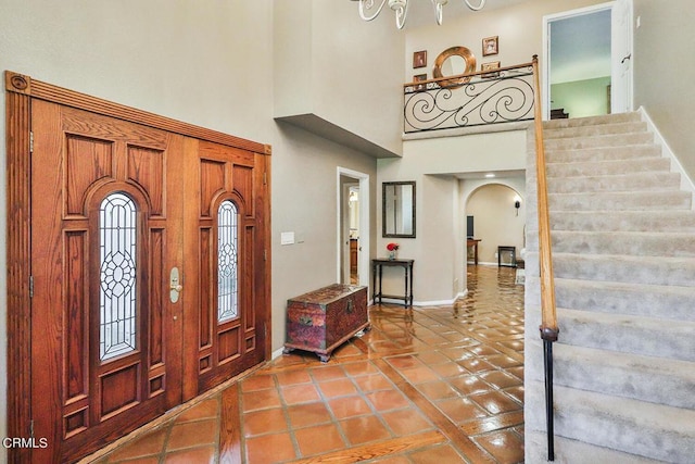 foyer entrance featuring tile patterned floors and a towering ceiling