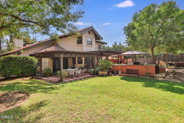 back of property featuring a pergola, a patio area, a yard, and a bar