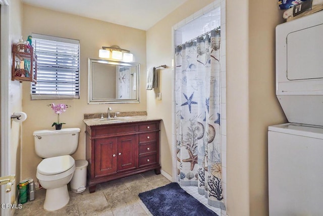 bathroom featuring walk in shower, vanity, stacked washing maching and dryer, and toilet