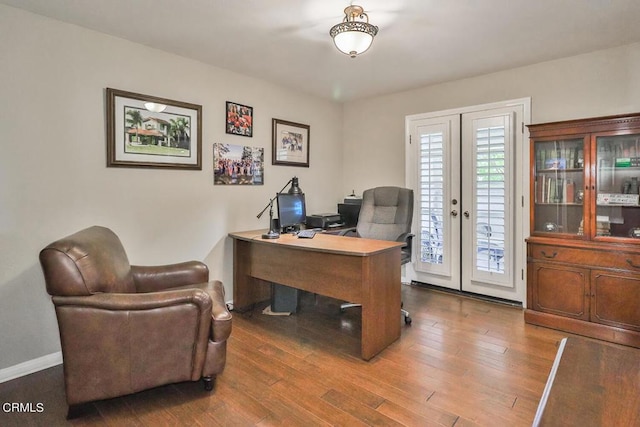 office with hardwood / wood-style flooring and french doors