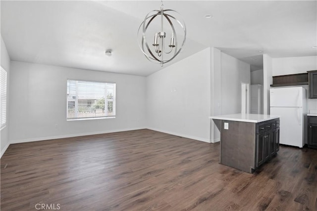 interior space featuring a chandelier, dark wood-type flooring, and vaulted ceiling