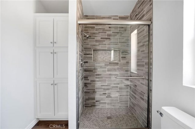 bathroom with toilet and an enclosed shower