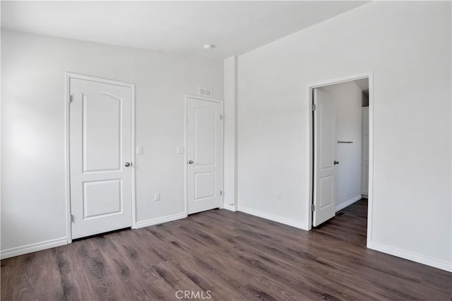 unfurnished bedroom featuring dark hardwood / wood-style floors