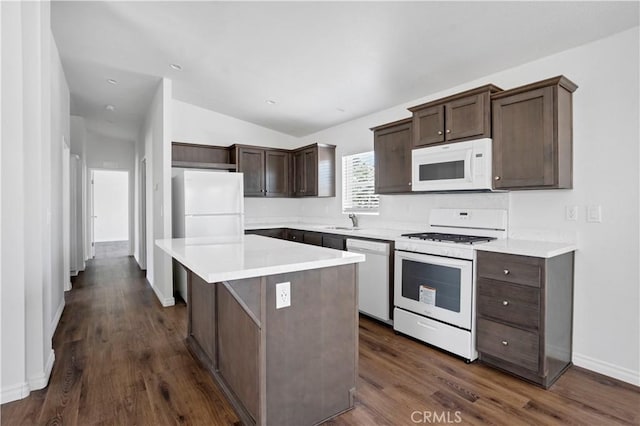 kitchen featuring white appliances, vaulted ceiling, sink, dark hardwood / wood-style floors, and a kitchen island