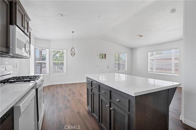 kitchen with pendant lighting, a center island, white appliances, vaulted ceiling, and dark hardwood / wood-style floors