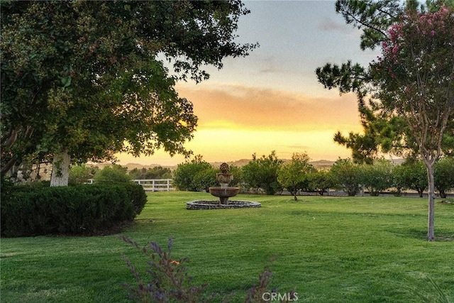 view of home's community with a lawn and fence