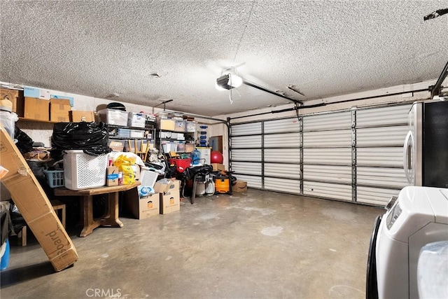 garage featuring stainless steel refrigerator, a garage door opener, and washer / clothes dryer