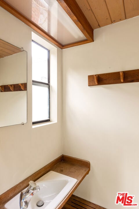 bathroom with wood ceiling, beamed ceiling, hardwood / wood-style floors, and sink