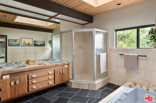 bathroom with independent shower and bath, beamed ceiling, a skylight, and vanity