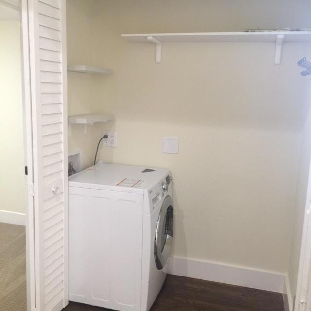 clothes washing area featuring washer / dryer and dark wood-type flooring