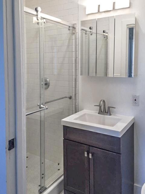 bathroom featuring vanity and an enclosed shower