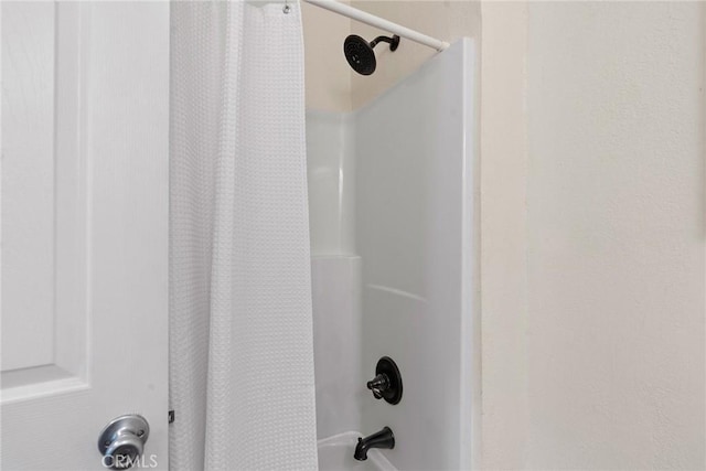 interior details featuring shower / bathtub combination with curtain