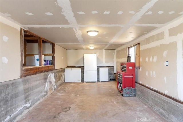 basement with fridge and white refrigerator