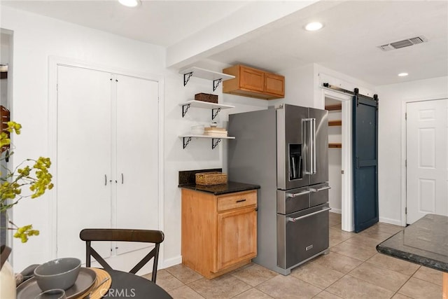 kitchen featuring a barn door, light tile patterned flooring, and high quality fridge