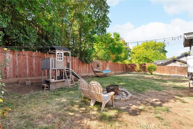 view of yard with a playground and an outdoor fire pit