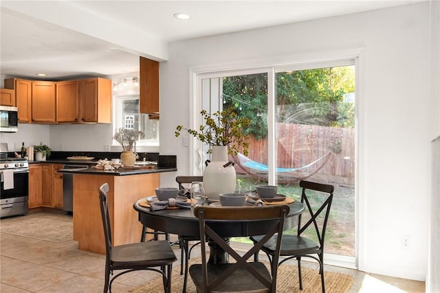 kitchen featuring light tile patterned flooring, stainless steel appliances, and kitchen peninsula