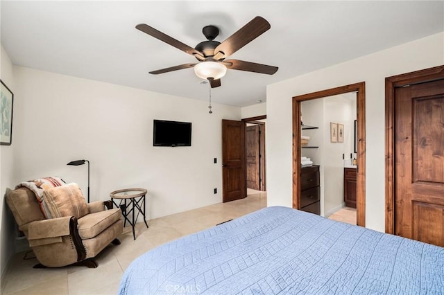 bedroom with light tile patterned floors, a ceiling fan, and ensuite bathroom