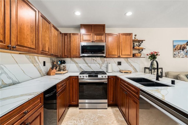 kitchen featuring appliances with stainless steel finishes, a sink, and light stone countertops