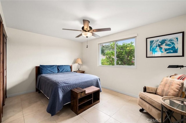 bedroom with light tile patterned floors, a ceiling fan, and baseboards