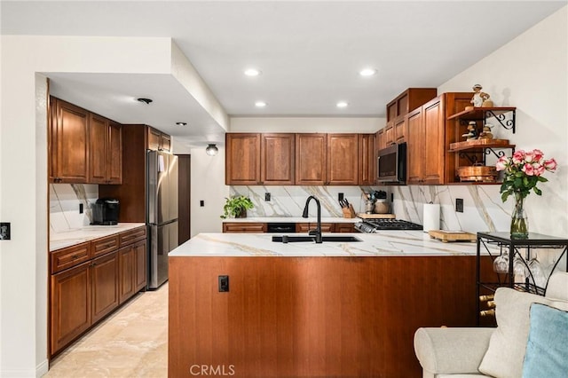 kitchen with a peninsula, a sink, appliances with stainless steel finishes, decorative backsplash, and open shelves