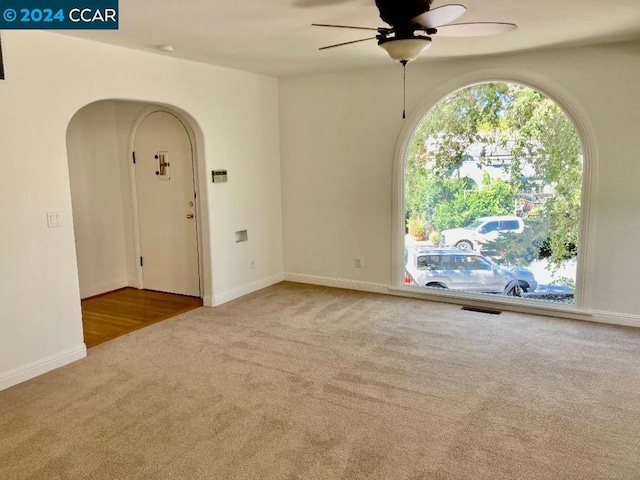 carpeted spare room featuring ceiling fan