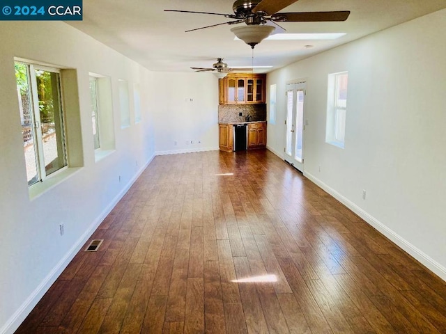 unfurnished living room featuring ceiling fan and dark hardwood / wood-style flooring