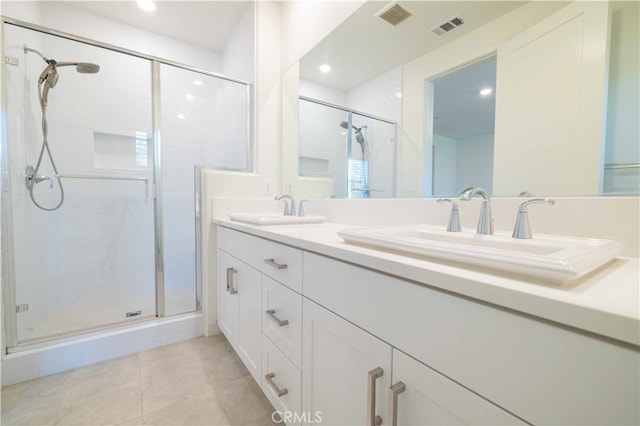 bathroom featuring tile patterned flooring, a shower with shower door, and vanity