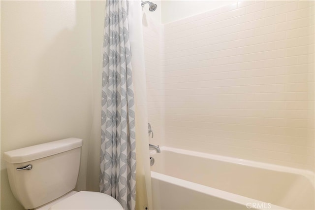 bathroom featuring shower / bath combo and toilet