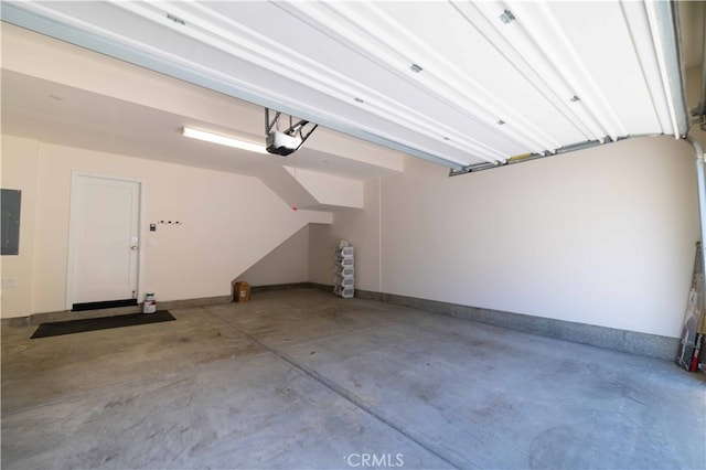 garage with a garage door opener and electric panel