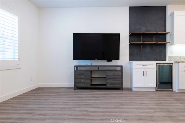 unfurnished living room with light hardwood / wood-style flooring and wine cooler