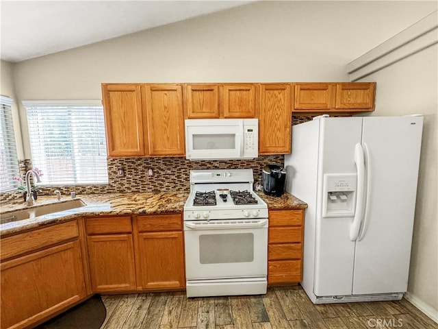 kitchen with hardwood / wood-style flooring, tasteful backsplash, sink, vaulted ceiling, and white appliances