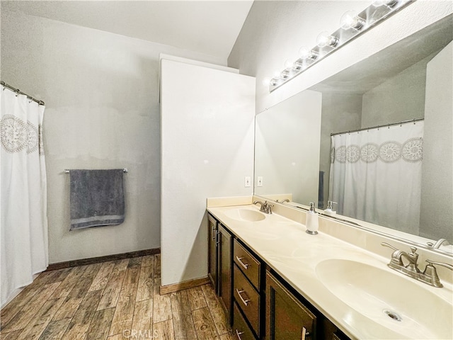 bathroom with lofted ceiling, hardwood / wood-style flooring, and vanity