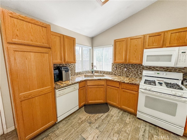 kitchen with light wood-type flooring, tasteful backsplash, sink, lofted ceiling, and white appliances