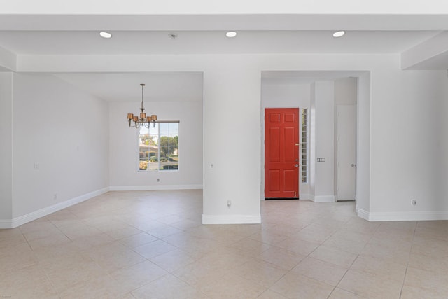 tiled empty room featuring a notable chandelier