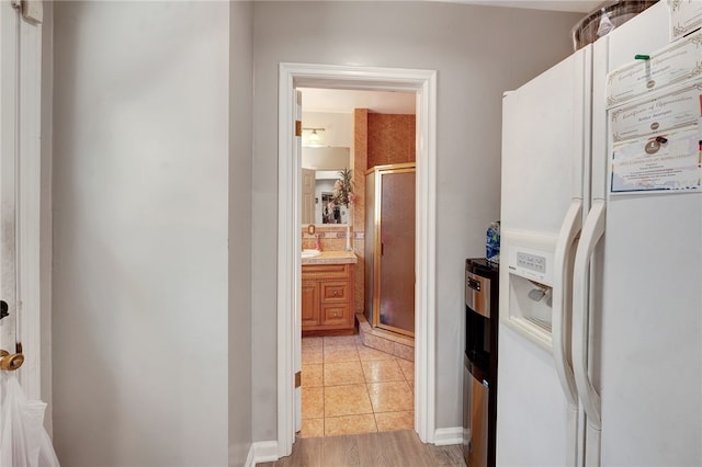 interior space featuring white fridge with ice dispenser and light tile patterned floors