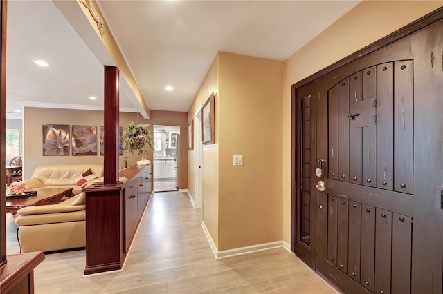 entrance foyer with plenty of natural light, light hardwood / wood-style floors, and crown molding